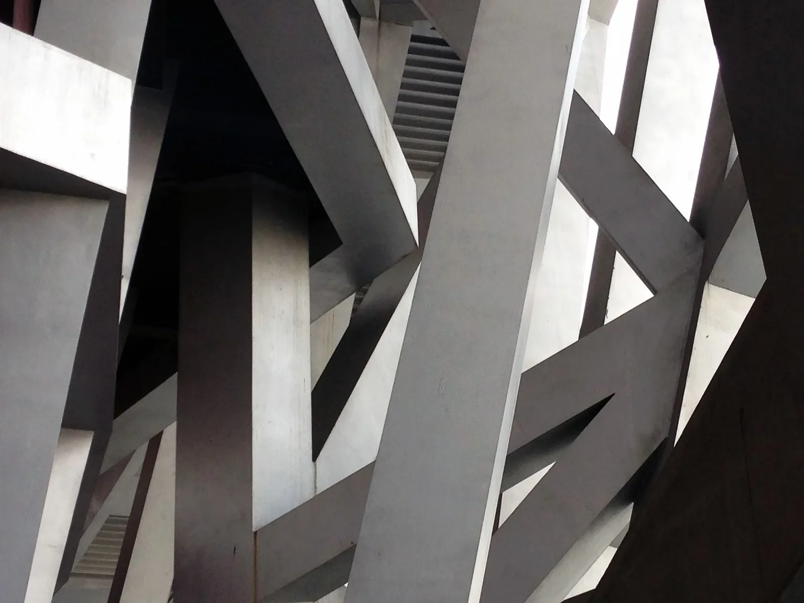 Close-up of tilted steel beams crossing in a dense structural lattice