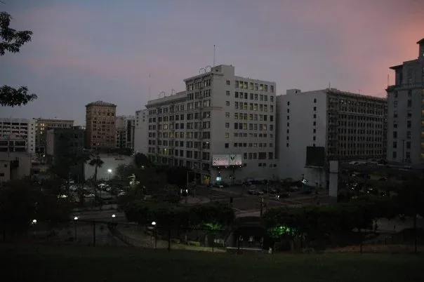 Dusk over a city block, an office building under a pink sky