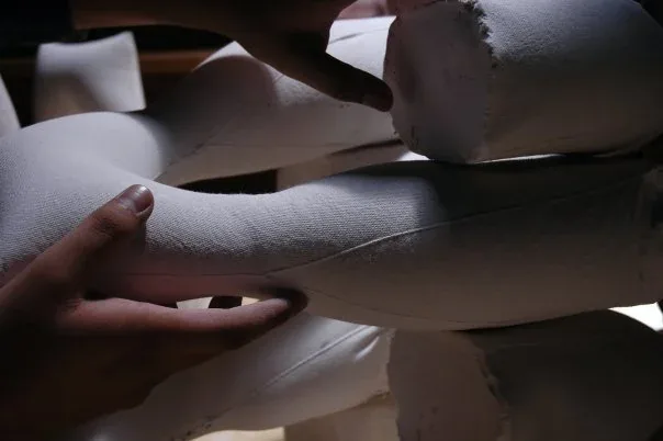 Hands shaping plaster-soaked fabric forms