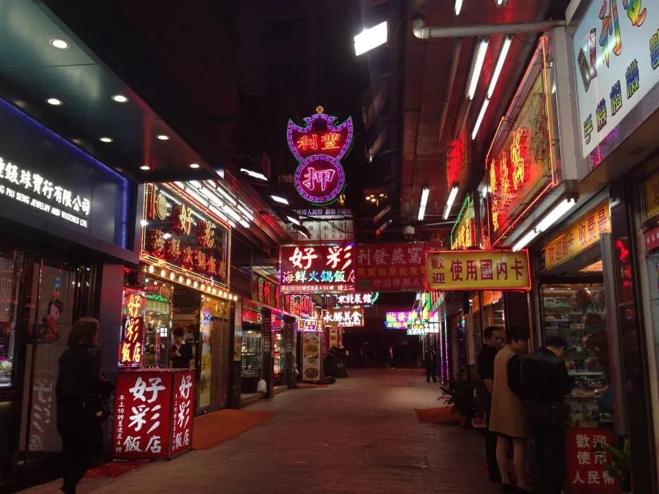 Neon-lit narrow street at night with Chinese signage